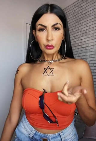 Sexy Sil enseña escote con Top Tubo Naranja Neón