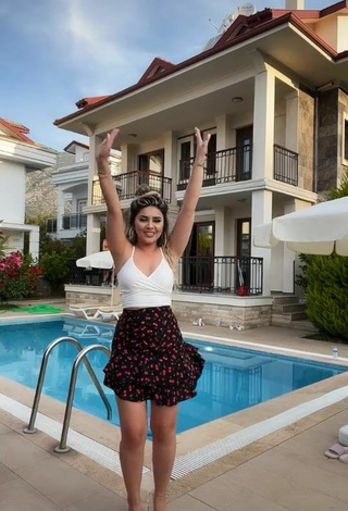 Hermosa Gizemjelii con Top Corto Blanco en la piscina