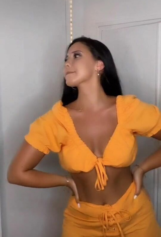 Atractiva Anissa enseña escote con Seductores Top Corto Naranja