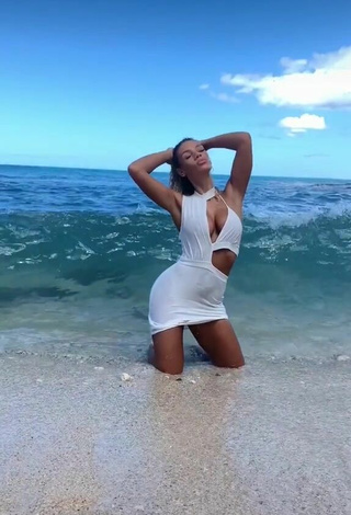 2. Sexy Jena Enseña Escote Con Vestido Blanco En La Playa